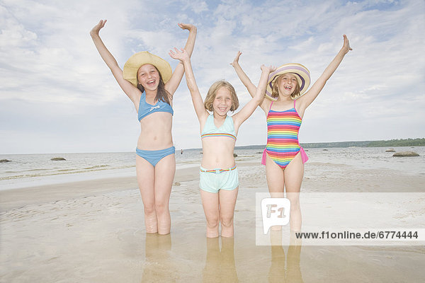 Portrait of three girls with their arms raised  Grand Beach  Manitoba