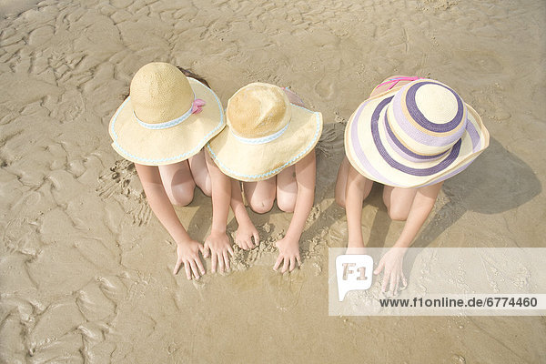 Three girls playing in sand  Grand Beach  Manitoba