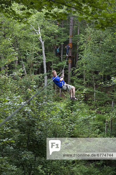 Man on a zip line between trees  Arbres en Arbres  Shawinigan  Quebec