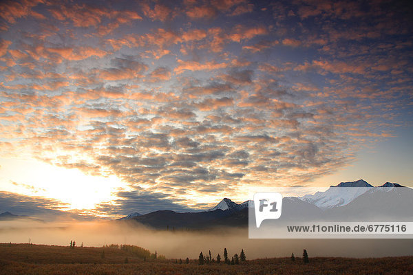 Clouds over Itsi Mountains with mist at sunrise  North Canol Road  Yukon