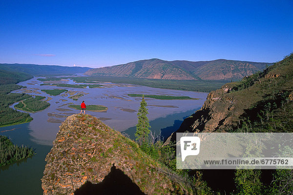 Hiker on a Hilltop above the confluence of the Yukon and White Rivers  Dawson City  Yukon