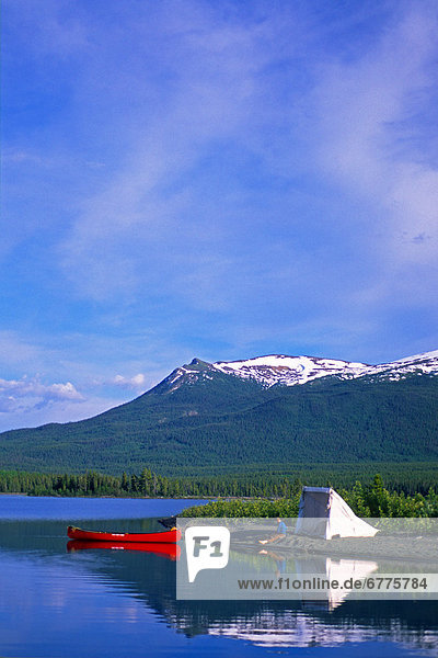 Man Relaxing by his Tent and Canoe while Camping along the Shores of Atlin Lake  Atlin  British Columbia