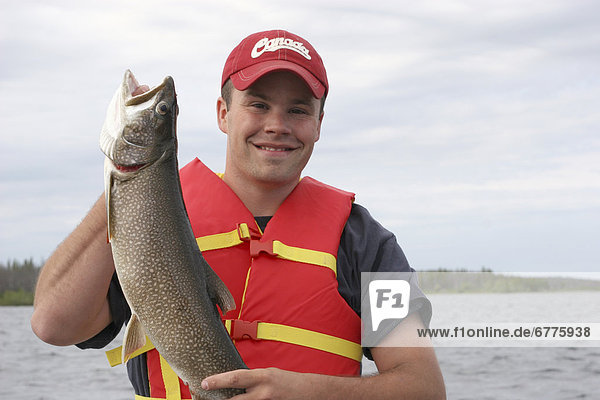 Portrait of a Man with a Lake Trout while Fishing on Tibbett Lake  outside Yellowknife  Northwest Territories