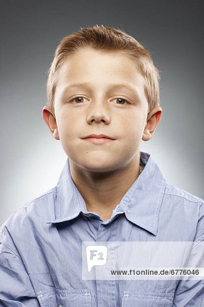 Portrait of boy (8-9) wearing shirt and looking at camera  studio shot