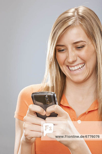 Studio portrait of young woman text messaging