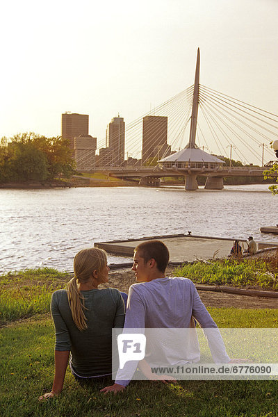 Teens Relaxing with Skyline and Red River in background  Winnipeg  Manitoba