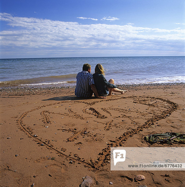 sitzend  nebeneinander  neben  Seite an Seite  Sand  herzförmig  Herz  Zeichnung  Gaspe  Quebec