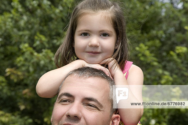 Portrait of young girl sitting on her Dad s shoulders  Ontario  Canada