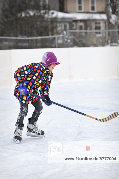 Young boy playing ice hockey on an outdoor rink  Winnipeg  Manitoba  Canada