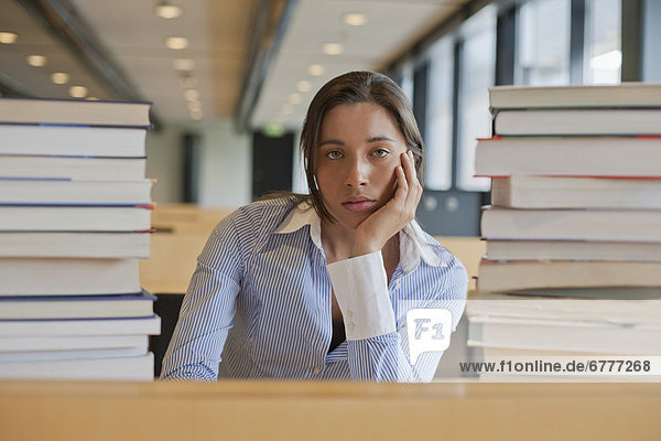 Portrait of female student between stacks of books