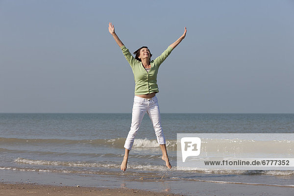 Springende Frau am Strand