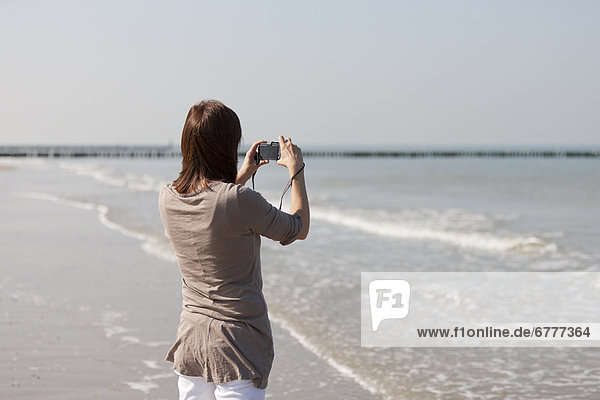 Woman on beach using camera