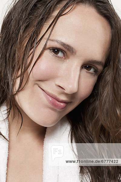 Portrait of smiling woman with wet hair  studio shot