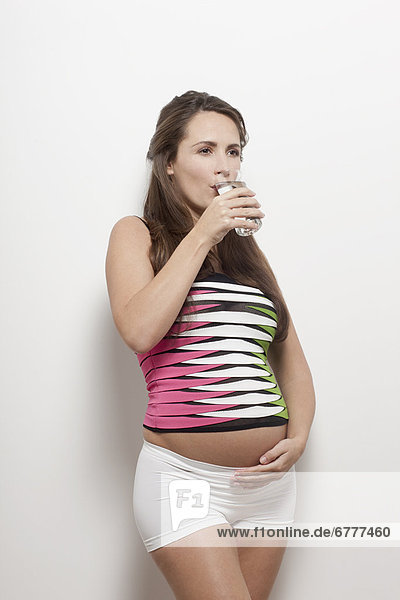 Portrait of pregnant woman drinking water  studio shot