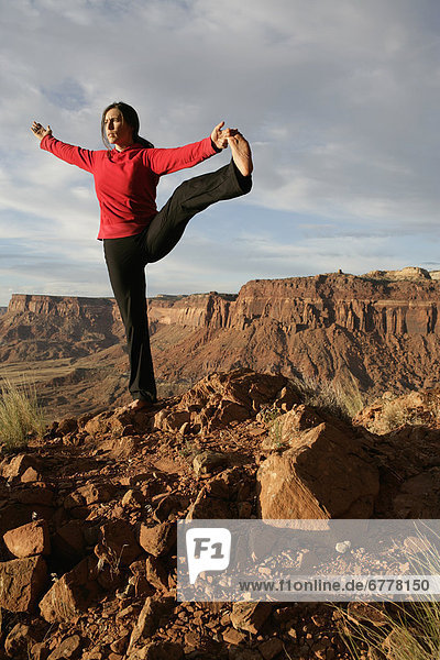 USA  Utah  Canyonlands National Park  woman stretching on rock