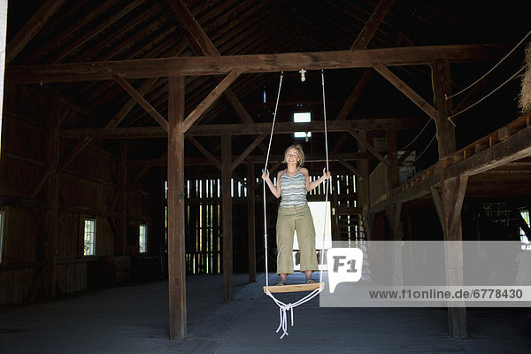 USA  Vermont  Dorset  Woman on swing in barn