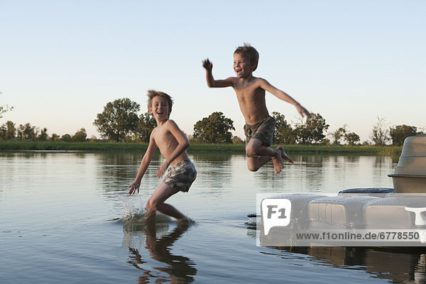 USA  Texas  Texarkana  Two boys (8-9) jumping into lake
