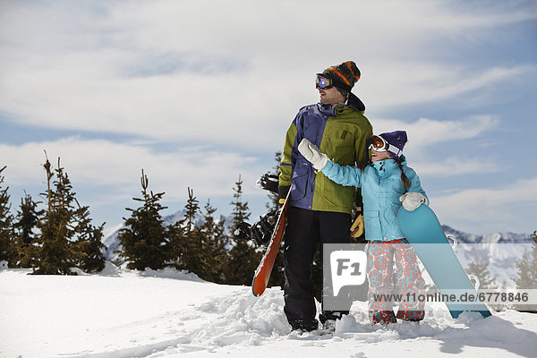 USA  Colorado  Telluride  Father and daughter (10-11) standing with snowboards in winter scenery