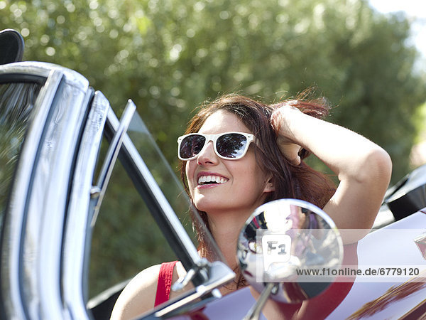 Smiling young woman in convertible car