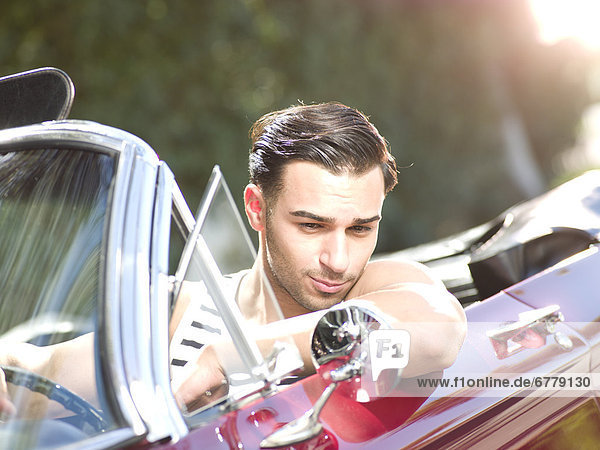 Smiling young man in convertible car