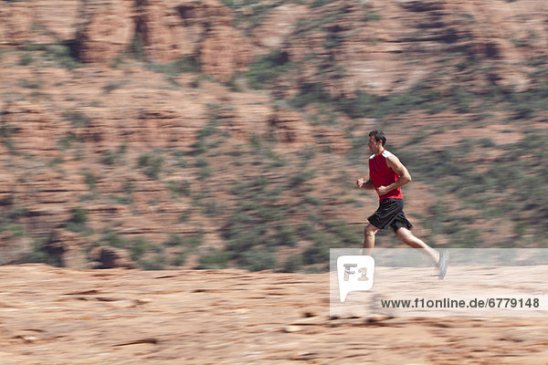 USA  Arizona  Sedona  Young man running in desert