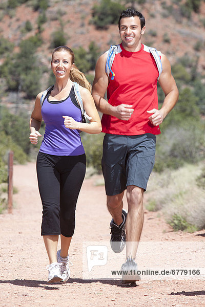USA  Arizona  Sedona  Young couple running in desert