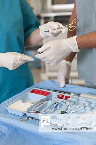 Midsection of surgeons holding tools