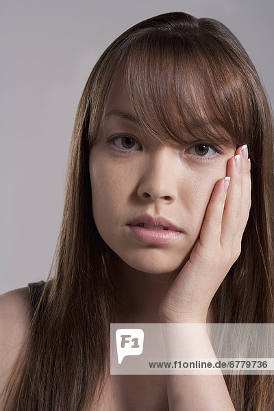 Portrait of young woman with tooth ache  studio shot