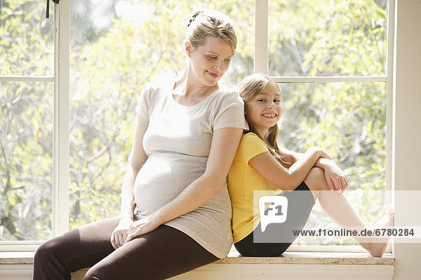 sitzend  umarmen  Schwangerschaft  Tochter  5-9 Jahre  5 bis 9 Jahre  Mutter - Mensch