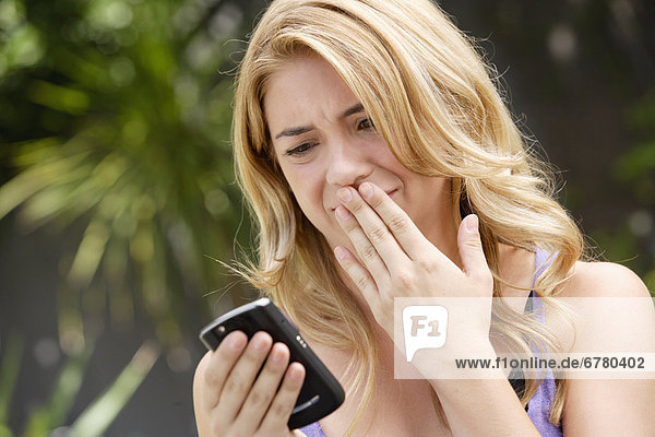 Young woman text-messaging  with facial expression