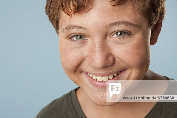 Studio portrait of boy (12-13) smiling