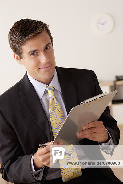 Portrait of businessman holding clipboard