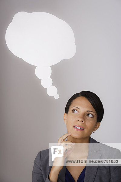 Studio shot of pensive business woman with speech bubble above head