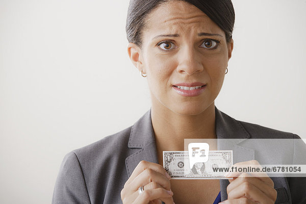 Studio shot of business woman holding small one dollar bill