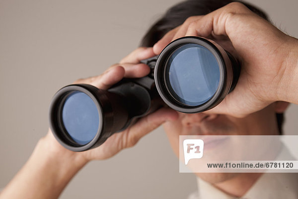 Businessman looking through binoculars