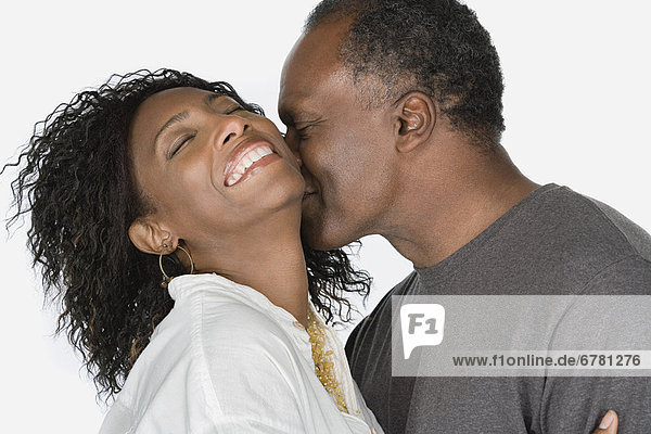 Studio portrait of mature couple kissing