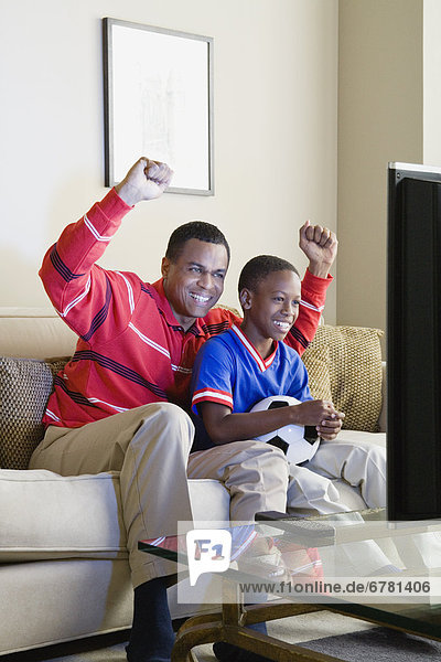 Father and Son (12-13) watching sports on tv