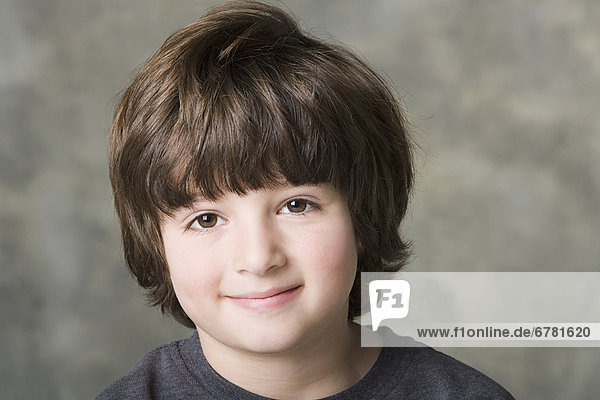 Portrait of smiling (6-7) boy  studio shot