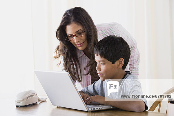 Mother doing homework with son (10-11)