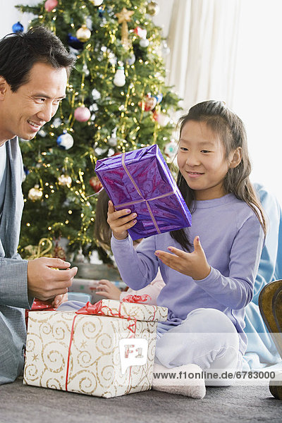 Father and daughter unwrapping christmas gifts