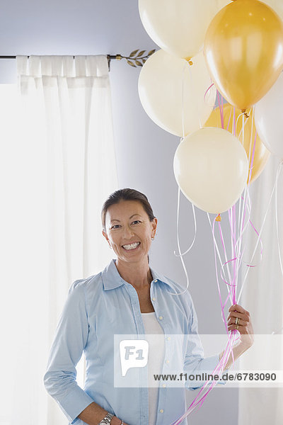 Portrait of mature woman with balloons
