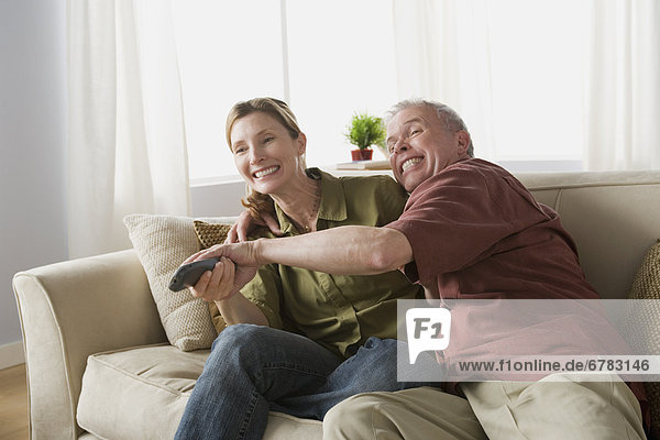 Couple fighting for tv remote