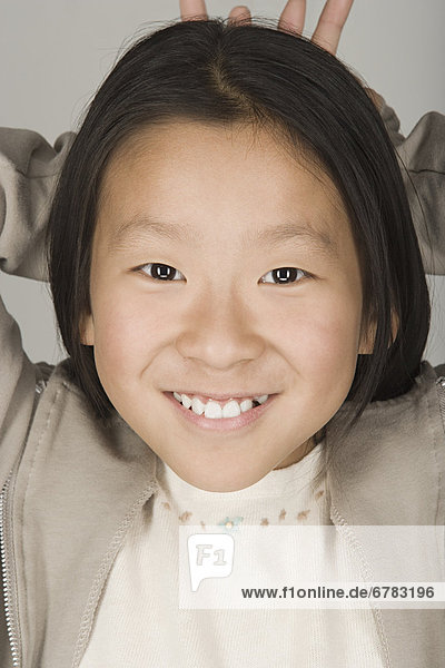 Studio portrait of teen (16-17) girl smiling