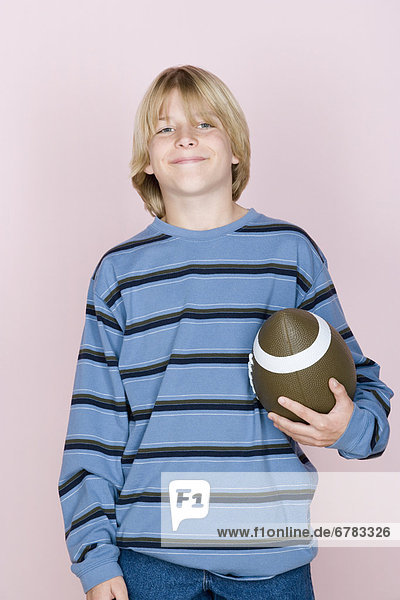 Oberkörperaufnahme  Portrait  Jugendlicher  Junge - Person  halten  schießen  Studioaufnahme  Ball Spielzeug  Rugby