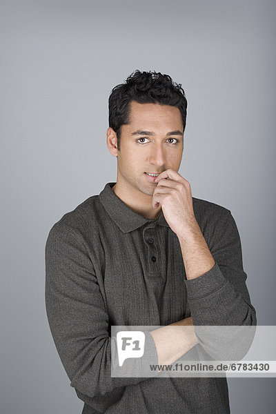 Studio shot portrait of mid adult man with finger on lips  waist up