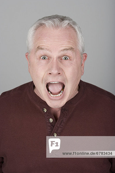 Studio portrait of scared senior man