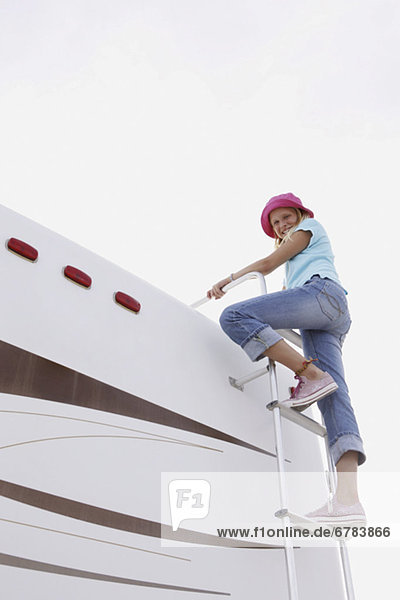 Girl climbing on motor home ladder