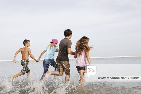 Children running in ocean
