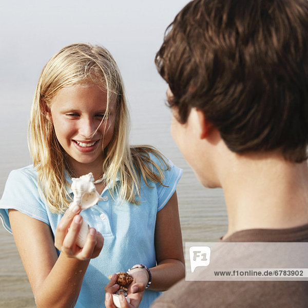 Girl showing shell to friend