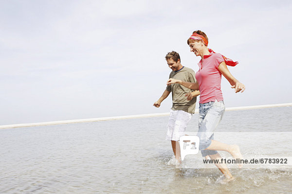 Couple running in ocean